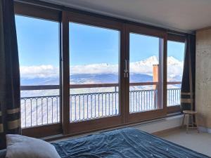 - une chambre avec une grande fenêtre donnant sur les montagnes dans l'établissement Apartment La Nova-2 by Interhome, à Arc 1800