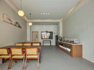 comedor con sillas, mesa y cama en Zhangjiajie JoyMaple Hotel, en Zhangjiajie