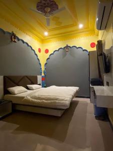 een slaapkamer met een bed met een schilderij aan de muur bij Hotel Simran Desert View Haveli in Pushkar