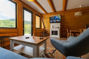a living room with a couch and chairs and a table at Chilia Houses in Mănăstirea Humorului