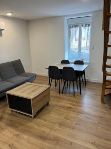 a living room with a couch and a table and chairs at Appartement F2 de 55 m2 in Blanzy
