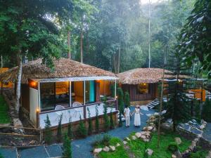 a couple standing in front of a house at เดอะริเวอร์ แม่กำปอง The River Maekampong Chiang Mai in Ban Pok Nai