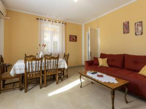 a living room with a red couch and a table at Holiday Home Adele by Interhome in Labin