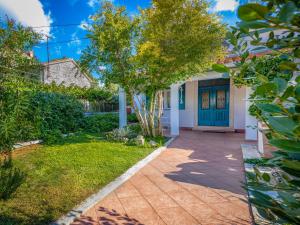 a house with a blue door and a yard at Holiday Home Adele by Interhome in Labin