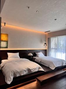 Un dormitorio con dos camas y una gran ventana. en Chaozhou Meisu Ancient City Store, en Chaozhou