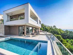 a house with a swimming pool in front of it at Villa Marmonte by Interhome in Lovran