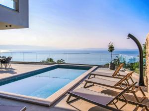 a swimming pool with chairs and a view of the ocean at Villa Marmonte by Interhome in Lovran