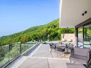 a patio with a table and chairs and a pool at Villa Marmonte by Interhome in Lovran