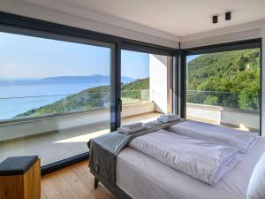 a bedroom with a bed and large glass windows at Villa Marmonte by Interhome in Lovran