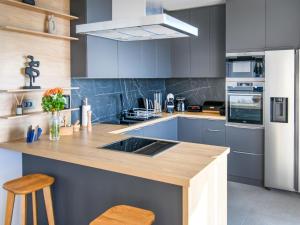 a kitchen with blue cabinets and a wooden counter top at Villa Marmonte by Interhome in Lovran +25 photos