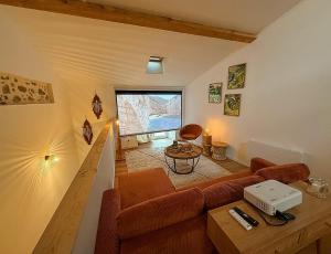 ein Wohnzimmer mit Sofa und Tisch in der Unterkunft L'Instant Suspendu - Loft & Spa in Saint-Girons