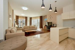een keuken en woonkamer met een bank en een tafel bij Sunrio Apartments in Budva