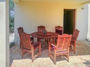 BrzacにあるHoliday Home Sandra by Interhomeの木製テーブル、椅子4脚、テーブル1台、椅子1脚