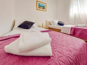 BrzacにあるHoliday Home Sandra by Interhomeのベッドルーム1室(ピンクと白のシーツが備わるベッド2台付)