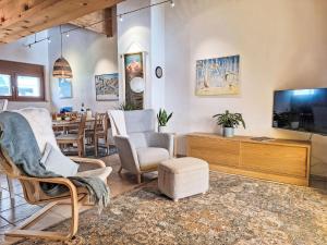 a living room with chairs and a tv and a table at Apartment Möösli Vue by Interhome in Sundlauenen