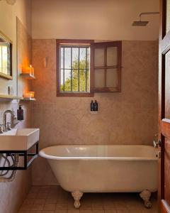 Un baño con bañera blanca y lavabo. en Cabañas Estancia Balumba, en Capilla del Monte