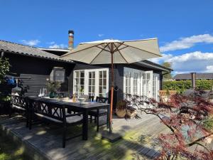 Holiday Home Yvette - 350m from the sea by Interhome في Hejlsminde: فناء مع طاولة ومظلة