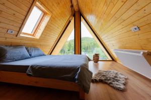 a bed in a room with a large window at Chilia Houses in Mănăstirea Humorului