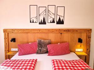 a bedroom with a bed with two red pillows at Apartment Almluft by Interhome in Weerberg +21 photos