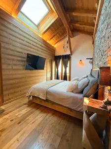 Un dormitorio con una cama en una habitación con paredes de madera. en Chalet Grand Area, en Briançon
