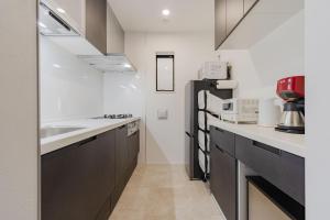 a kitchen with a sink and a refrigerator at AMBLE Asakusa in Tokyo