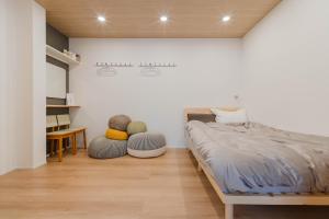 a bedroom with a bed and two ottomans at AMBLE Asakusa in Tokyo