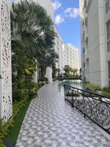 een loopbrug tussen twee gebouwen met een hek bij Olympus City Garden Condo Pattaya High Floor 8F in Ban Nong Chaeng