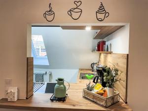 a kitchen with a table with a coffee pot decals on the wall at Apartment Die Dorfperle by Interhome in Wanna