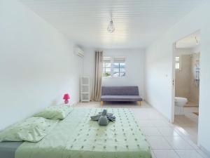 a bedroom with a large bed and a blue couch at Villa Zenitude Caraïbes in Les Trois-Îlets +13 photos