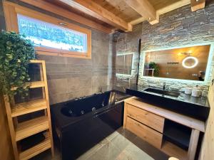 baño con bañera negra y lavamanos en Chalet Grand Area, en Briançon 39 fotos más