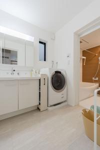 a bathroom with a sink and a washing machine at AMBLE Asakusa in Tokyo