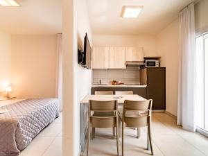 een keuken en een slaapkamer met een tafel en stoelen bij Apartment Iris Suite-3 by Interhome in Bibione +16 foto's