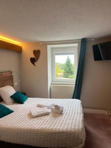 a bedroom with a bed with two towels on it at Hôtel Restaurant Valneige in Mittlach +20 photos