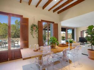 een eetkamer met een grote houten tafel en stoelen bij Villa Cala Figuera in Santanyi