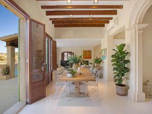 een eetkamer met een houten tafel en stoelen bij Villa Cala Figuera in Santanyi +6 foto's