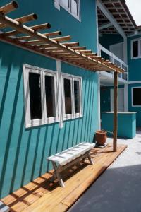 a blue building with a bench on a wooden deck at Pousada Quintal da Praça in Prado