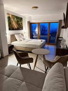 a living room with two beds and a table and chairs at Szent László Residence in Mátraszentimre