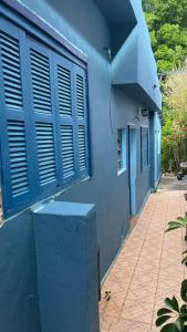 a blue building with blue windows and a brick sidewalk at Pousada Papirella in São Gabriel