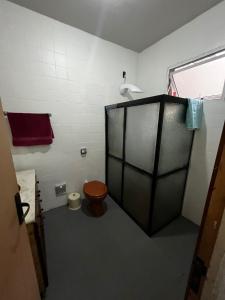 a small bathroom with a toilet and a window at Pousada Papirella in São Gabriel