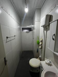 a small bathroom with a toilet and a sink at Pousada Papirella in São Gabriel