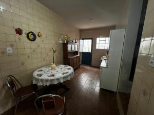 a small kitchen with a table and a refrigerator at Pousada Papirella in São Gabriel