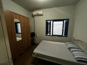 a small bedroom with a bed and a window at Pousada Papirella in São Gabriel
