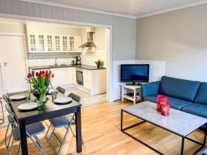 a living room with a blue couch and a table at Apartment Samlen Vasselgård by Interhome in Herand