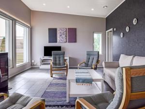 un soggiorno con divano, sedie e TV di Holiday Home Tervaleppä by Interhome a Sipsiö