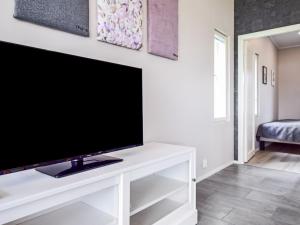 una TV a schermo piatto seduta sopra un centro di intrattenimento bianco di Holiday Home Tervaleppä by Interhome a Sipsiö Altre 25 foto
