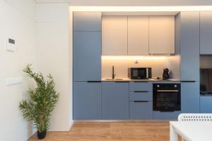 eine Küche mit blauen und weißen Schränken und einer Pflanze in der Unterkunft GuestReady - A peaceful city refuge in Porto