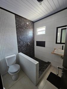 a bathroom with a toilet and a tub and a sink at Casa 264 in Capão da Canoa