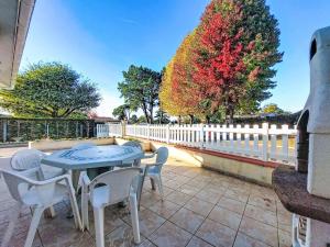 Holiday Home Laplace by Interhome في سوستون: طاولة وكراسي على فناء مع سياج