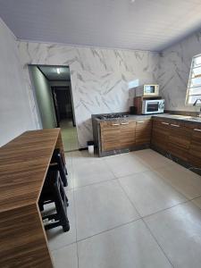 a kitchen with a counter and a marble wall at Casa 264 in Capão da Canoa