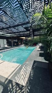 a swimming pool with a black and white roof at Pavema Apartments in Paramaribo